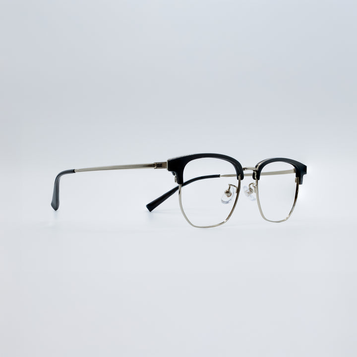 Eyeglasses with black and gold frame on a light gray background